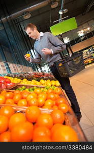 Man carrying basket while buying fruits in the supermarket