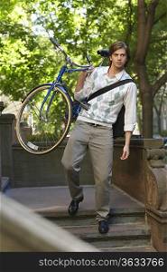 Man carrying bicycle, descending steps