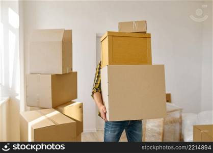 Man carrying big cardboard boxes stack. Starting new life in just bought house and moved in. Man carrying many cardboard boxes in stack