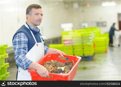 Man carrying crate of crabs