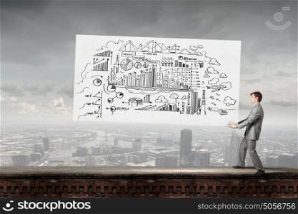 Man carrying ideas. Young businessman carrying his great business plan in hands