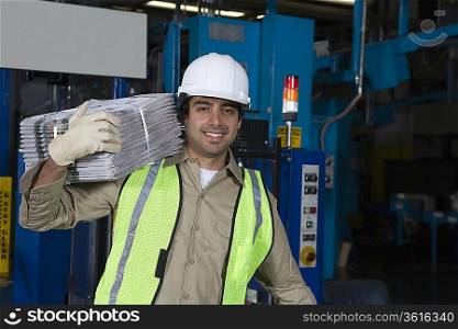 Man carrying newspapers in factory