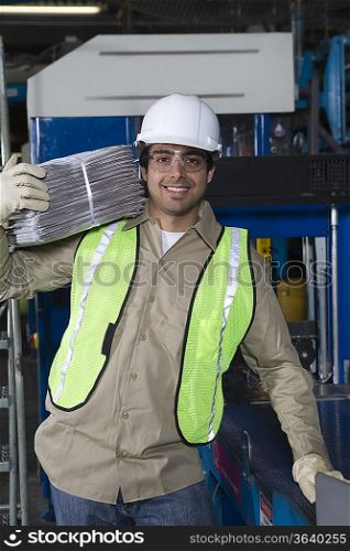Man carrying newspapers in factory