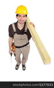 Man carrying planks over shoulder