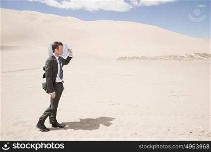 Man carrying water bottle in desert