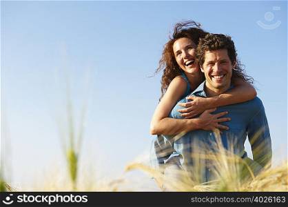 Man carrying woman in a wheat field