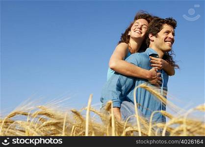 Man carrying woman in a wheat field