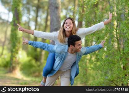 man carrying woman partner on his shoulders