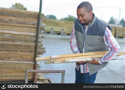 Man carrying wood in materials store