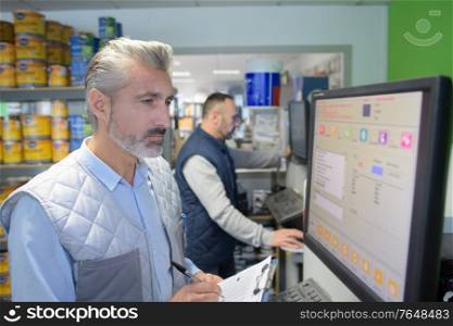 man cashier standing at pay desk in a household store