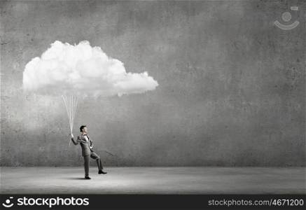 Man catch cloud. Young businessman caught white cloud with rope
