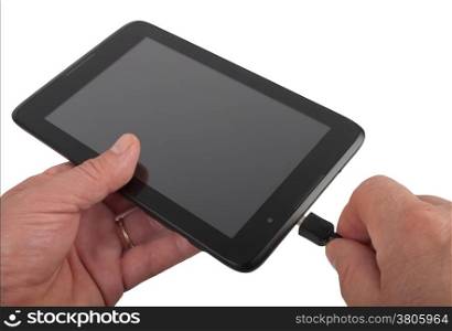 man charging black tablet, studio shot