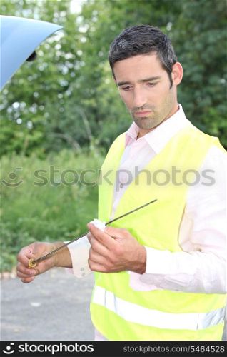Man checking his oil dipstick