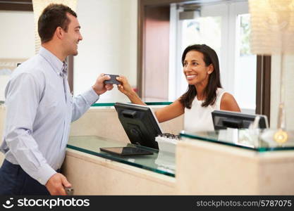 Man Checking In At Hotel Reception