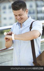 Man Checking Smart Watch Whilst Walking To Work