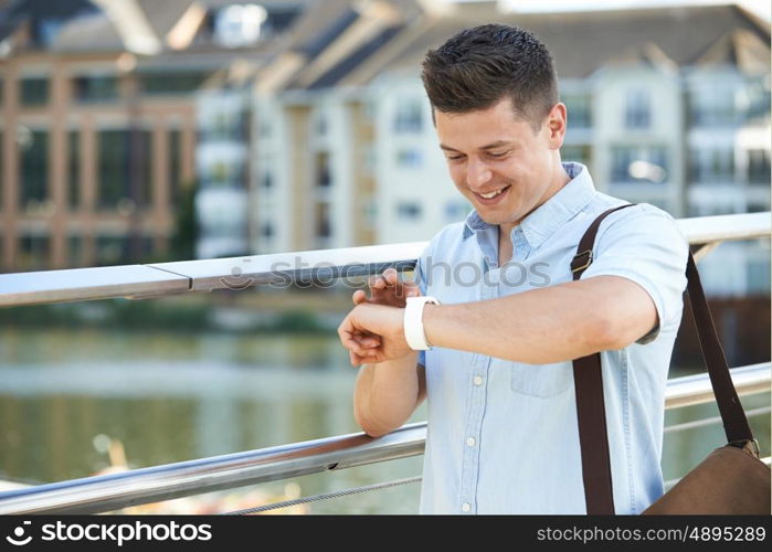 Man Checking Smart Watch Whilst Walking To Work