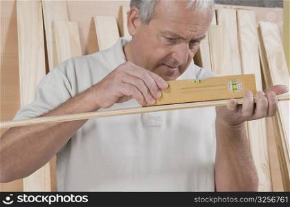 Man checking the level of a wooden plank