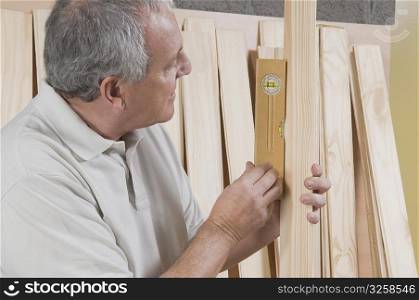 Man checking the level of a wooden plank