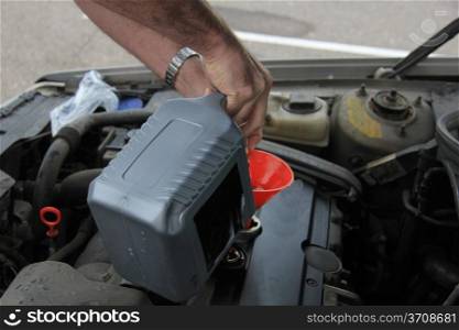 Man checking the oil level of a car