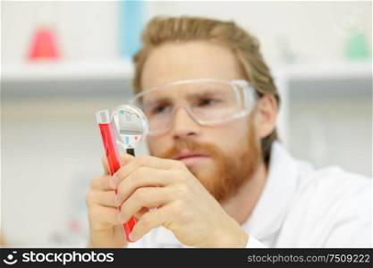 man chemist working in the lab with magnifying glass