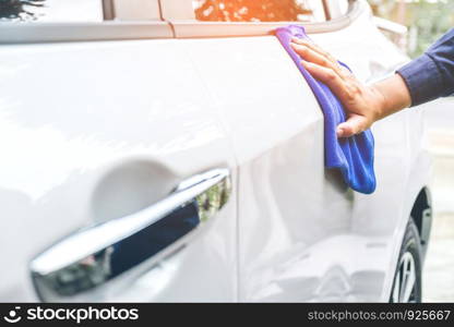 man cleaning car with microfiber cloth white car