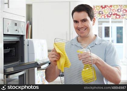 Man Cleaning Domestic Oven In Kitchen
