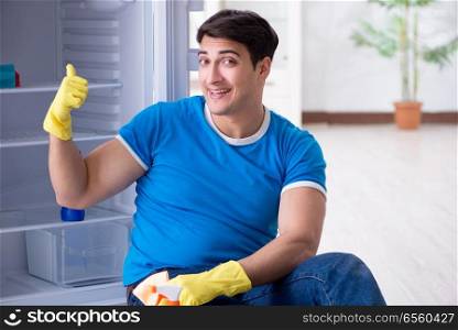 Man cleaning fridge in hygiene concept