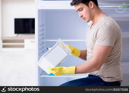 Man cleaning fridge in hygiene concept