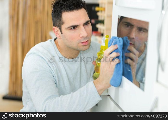 man cleaning oven at home