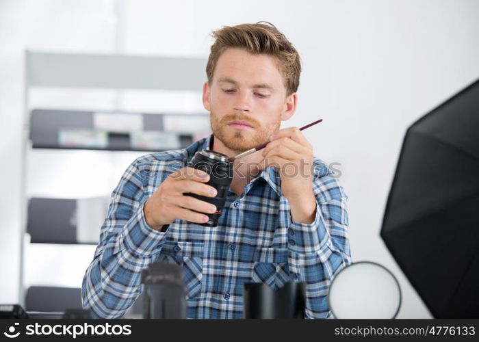 man cleaning photographic lense