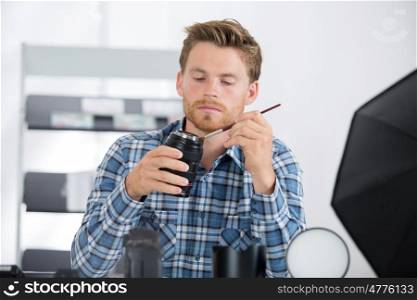 man cleaning photographic lense