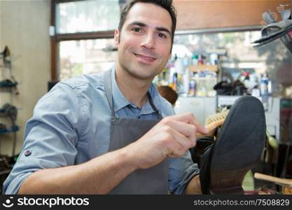 man cleaning shoes with brush
