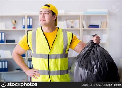 Man cleaning the office and holding garbage bag