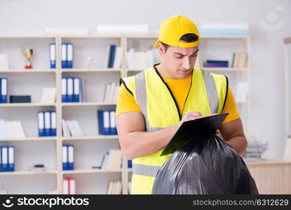 Man cleaning the office and holding garbage bag