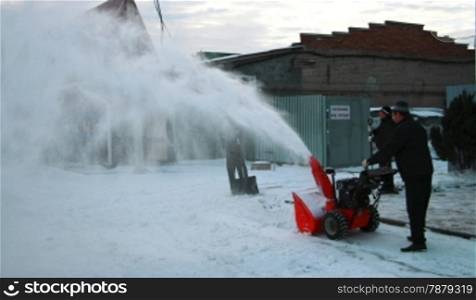 Man cleaning the yard. Snow removal by machine