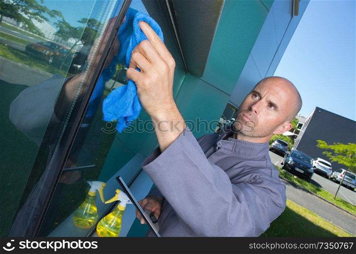 man cleaning window in his house