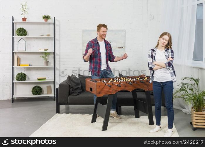 man clenching her fist with joy looking sad woman modern living room