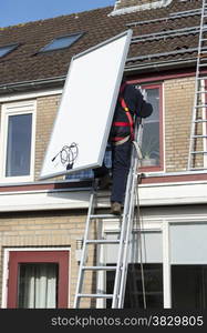 man climbing the ladder to the roof with solar panel