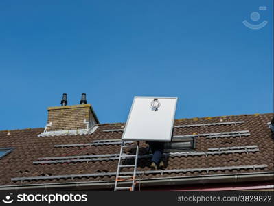 man climbing the ladder to the roof with solar panel