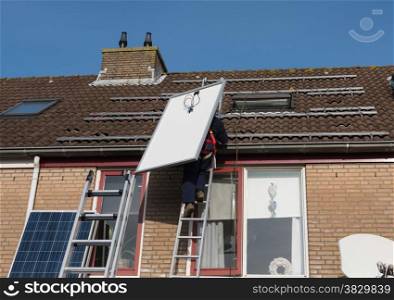 man climbing the ladder to the roof with solar panel