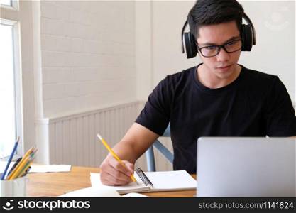 man college student studying learning lesson with computer online & taking note