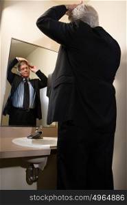 Man combing his hair in mirror