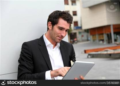 Man connected on internet with electronic tablet in town