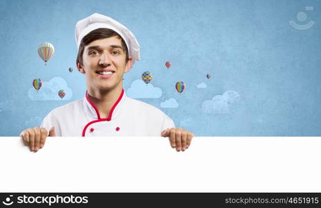 Man cook. Young handsome cook holding white blank banner