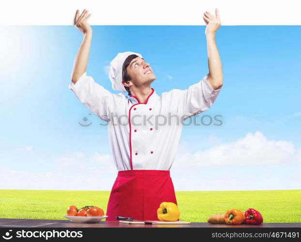 Man cook. Young handsome cook holding white blank banner