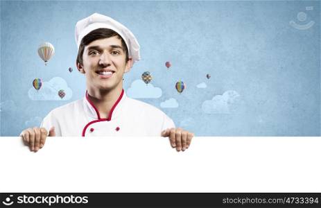 Man cook. Young handsome cook holding white blank banner