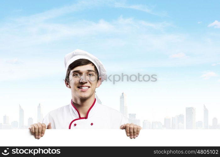 Man cook. Young handsome cook holding white blank banner