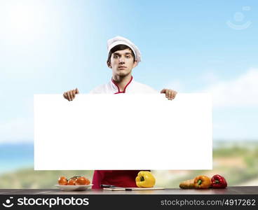 Man cook. Young handsome cook holding white blank banner