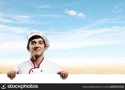 Man cook. Young handsome cook holding white blank banner