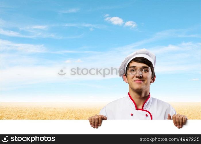 Man cook. Young handsome cook holding white blank banner